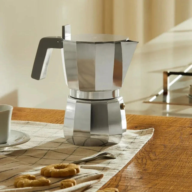 Alessi Moka Espressokocher in Grau auf der Arbeitsplatte mit Gebäck