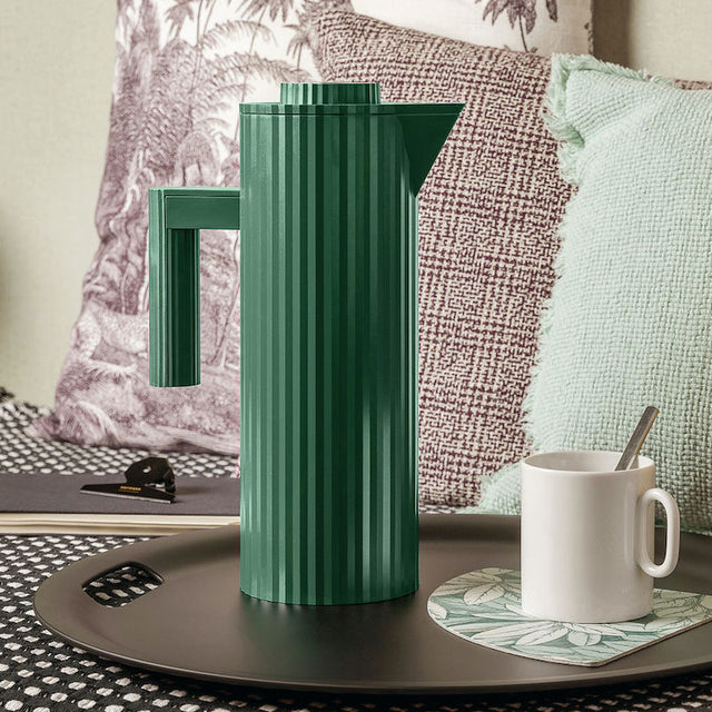Alessi Plissé Thermoskanne in Grün mit Tasse auf dem Tisch