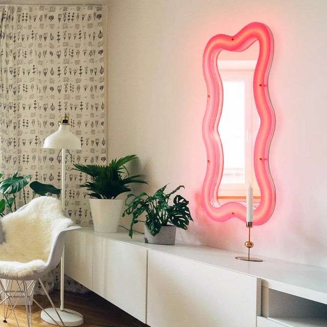 Seletti Supercurve Tiny Tall Wandspiegel mit Beleuchtung über einem weißen Sideboard im Wohnzimmer
